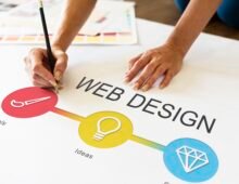 Designer planning a web design concept on paper with colorful icons representing tools, ideas, and creativity.