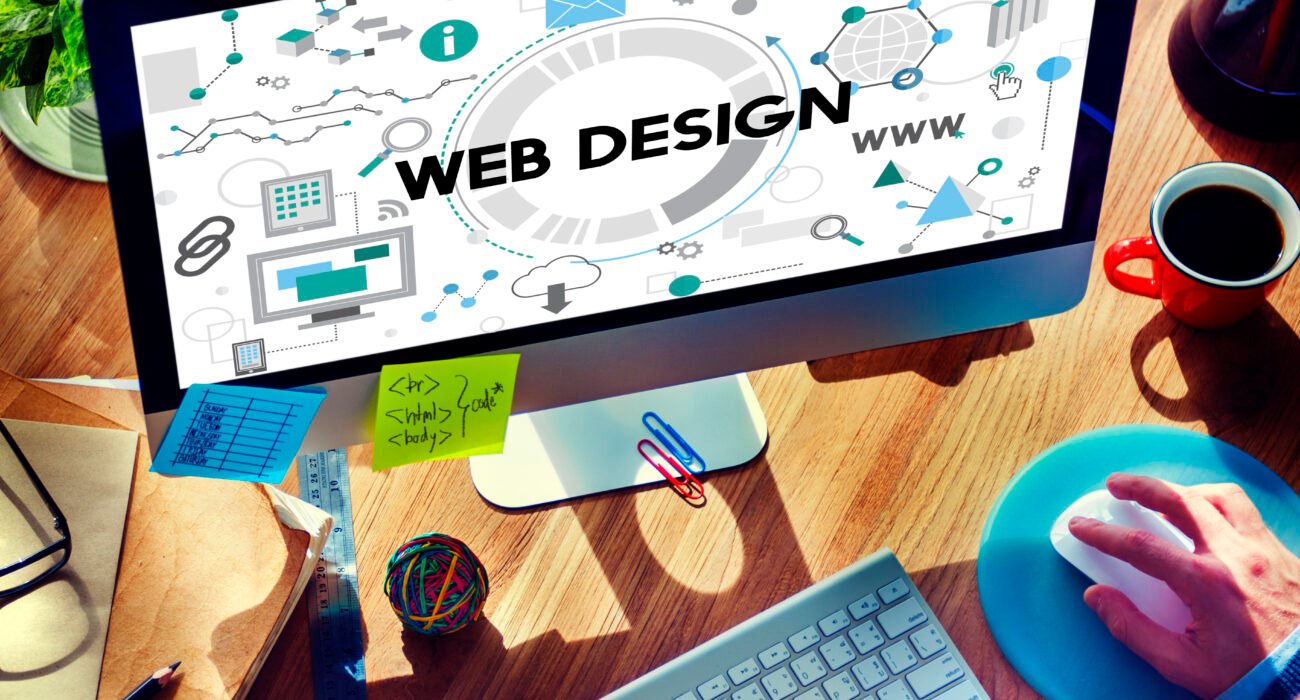 Business website design and development displayed on a computer screen with web graphics and programming concepts.