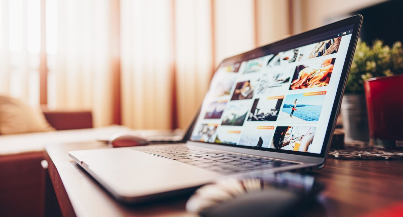 Laptop displaying a business website on a wooden desk in a modern workspace.